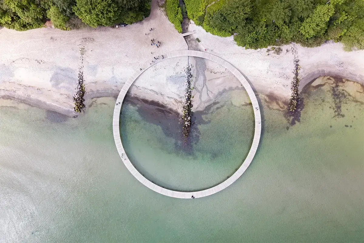 Ein Kreisverkehr über dem Wasser in Dänemark, aufgenommen aus der Vogelperspektive. Drohnenaufnahmen zeigen die Architektur und die Küstenlinie.