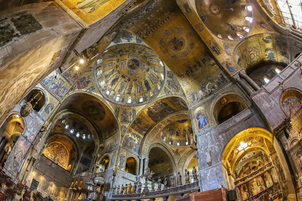 Intérieur doré de la basilique Saint-Marc, avec ses dômes ornés de mosaïques byzantines racontant des histoires sacrées.