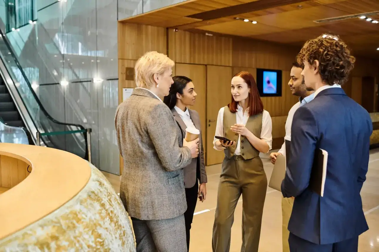 A diverse group of professionals in a modern office lobby, discussing ideas and promoting DEI.