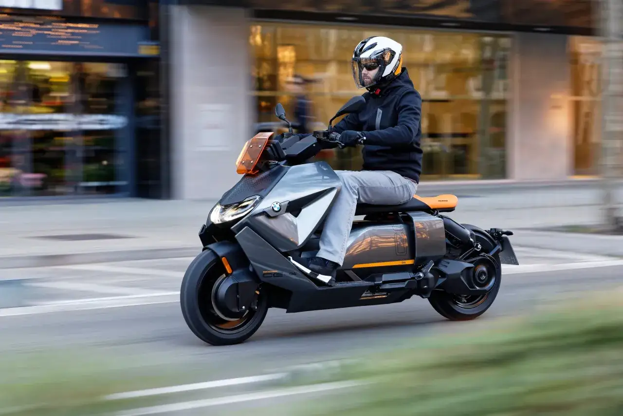 Mężczyzna w kasku jedzie na skuterze BMW C Evolution po mieście.