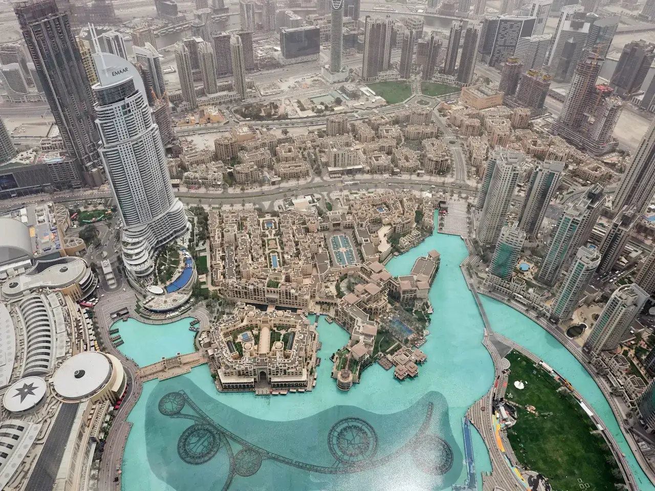 Widok z góry na Dubaj, gdzie jest Burj Khalifa, z wieżowcami, kanałami i fontannami.