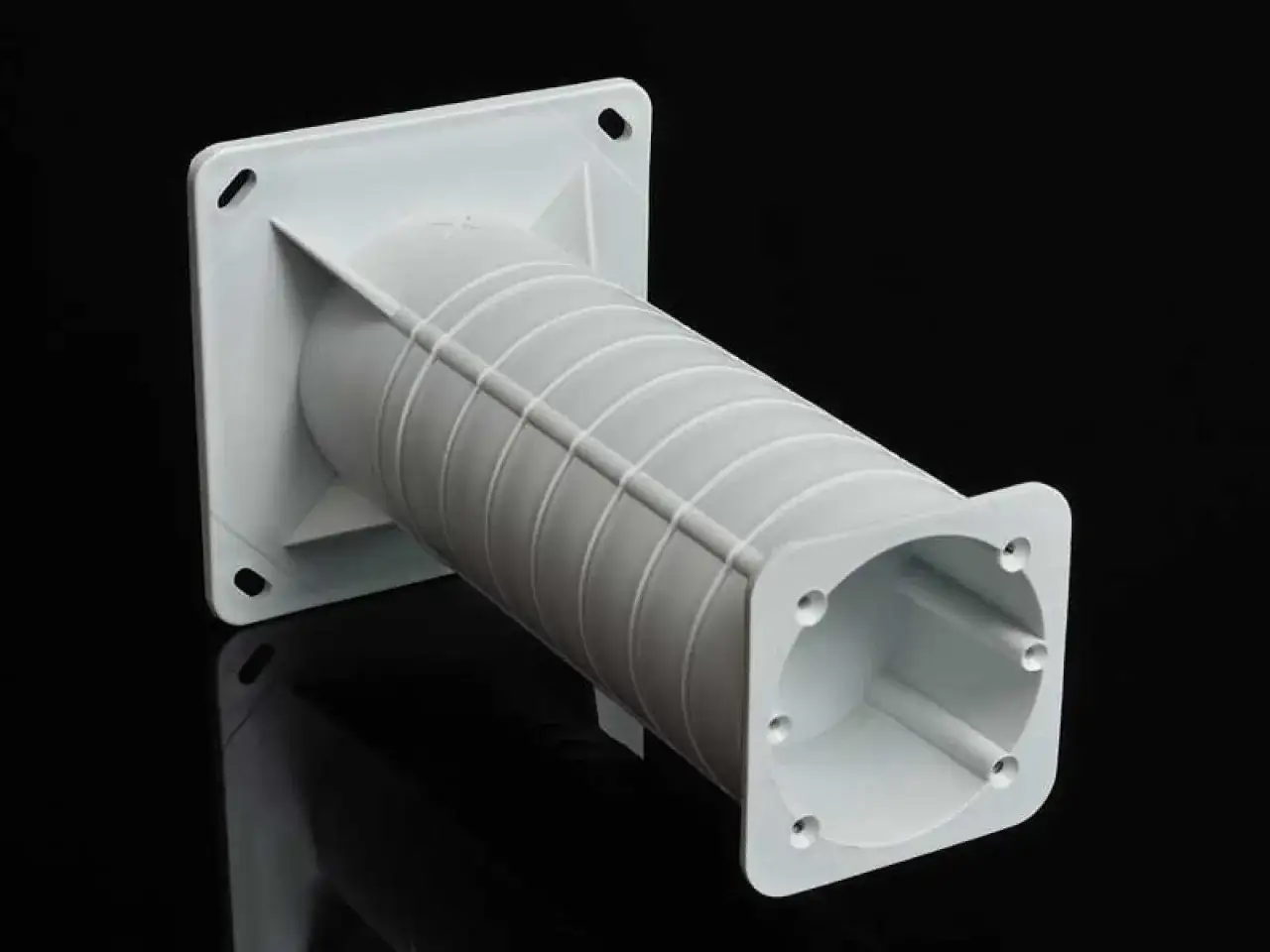 Biały, plastikowy element do mocowania lampy do styropianu. Kwadratowa podstawa z otworami i wydłużona, karbowana rura.