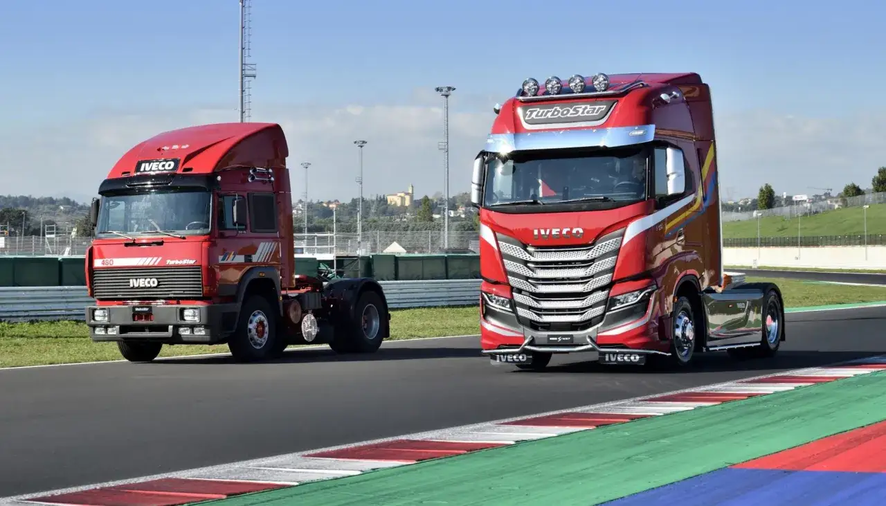 Dos camiones Iveco TurboStar rojos, uno clásico y otro moderno, en una pista.