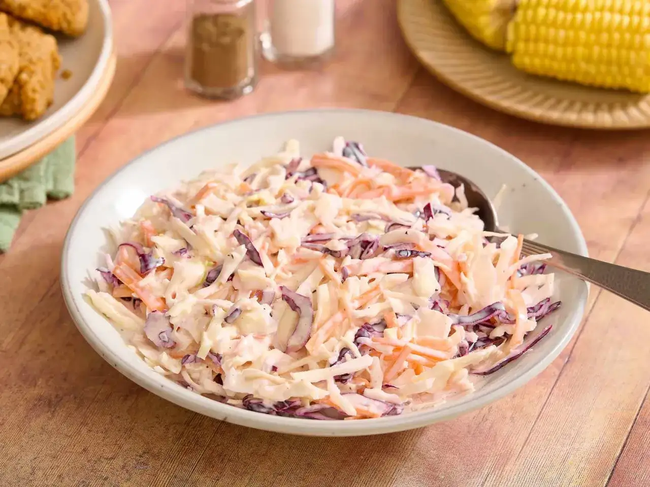 Un plato de ensalada americana cremosa, con repollo rallado, zanahoria y un toque de morado.