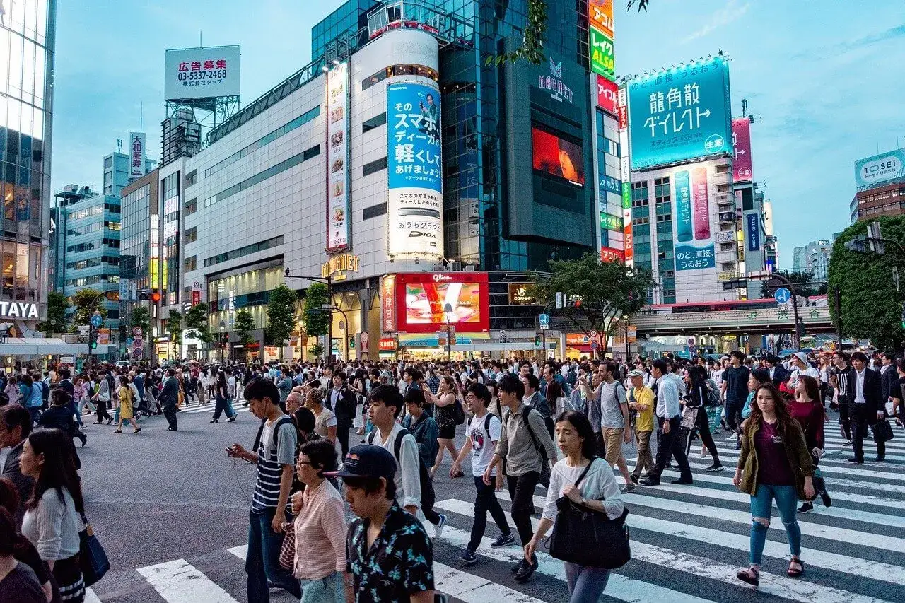 Tłum ludzi na ruchliwym skrzyżowaniu w Tokio. Zastanawiasz się, ile kosztuje wycieczka do Japonii? To tętniące życiem miasto oferuje niezapomniane wrażenia.