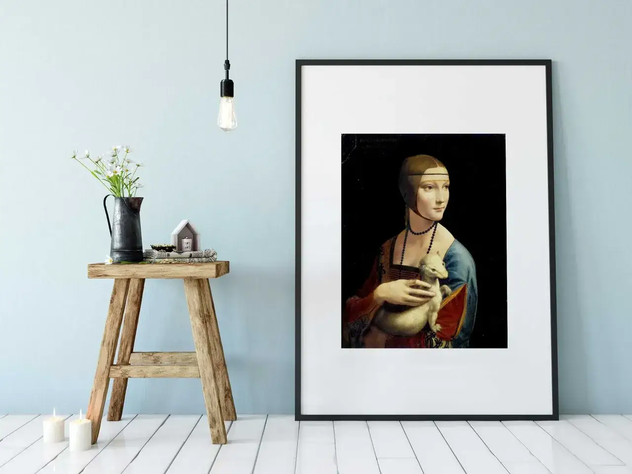 Dama z łasiczką, obraz Leonarda da Vinci, w czarnej ramie na jasnoniebieskiej ścianie.
