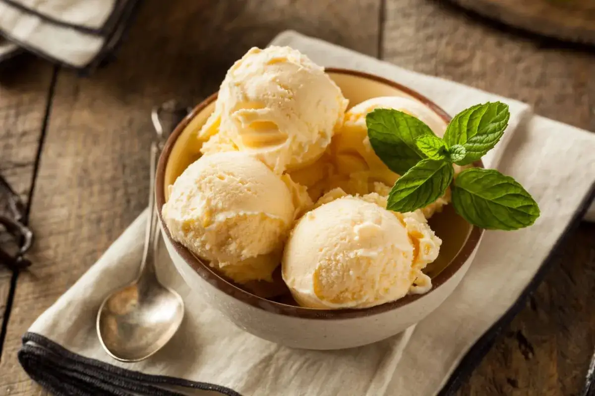 Schüssel mit cremigem Eis mit Kondensmilch, garniert mit Minze.