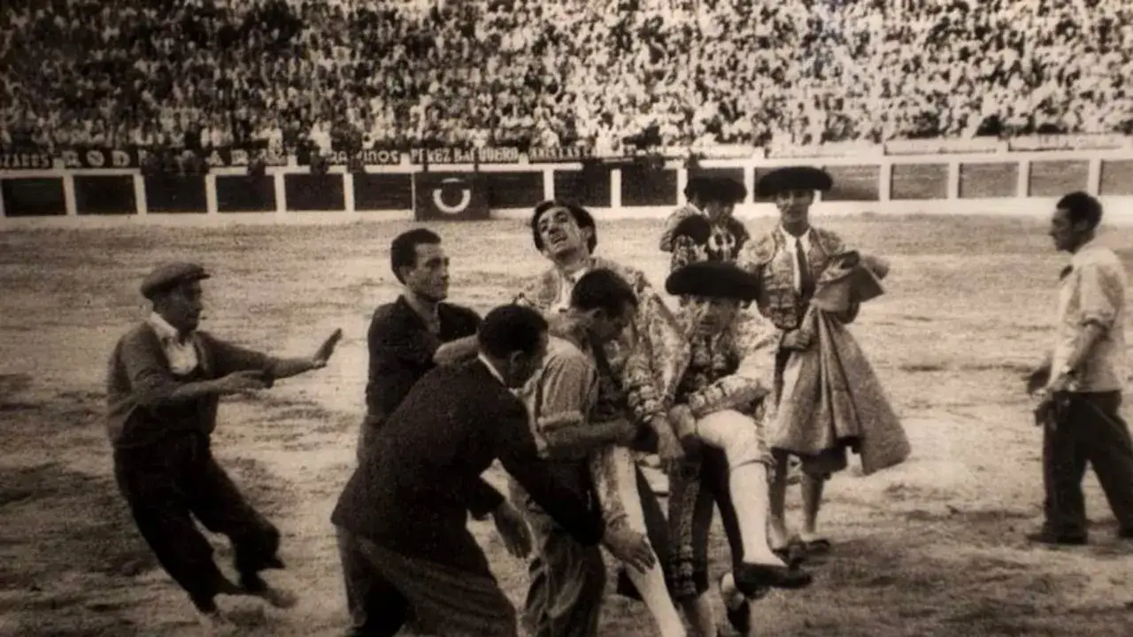 Momento dram&aacute;tico en la plaza. Toreros y asistentes ayudan a un hombre tras la **manolete cornada**.