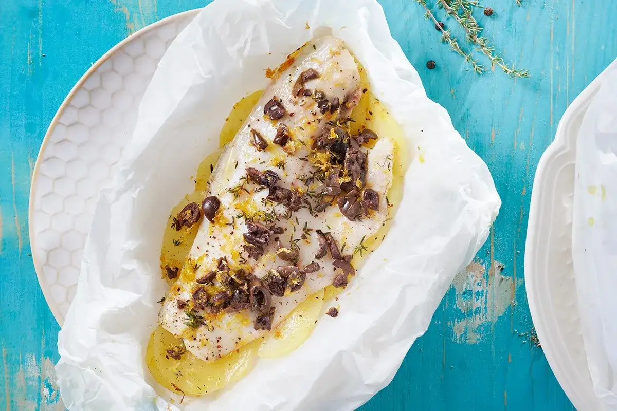 Filetto di pesce al forno con patate, olive e limone, un delizioso secondo di pesce.