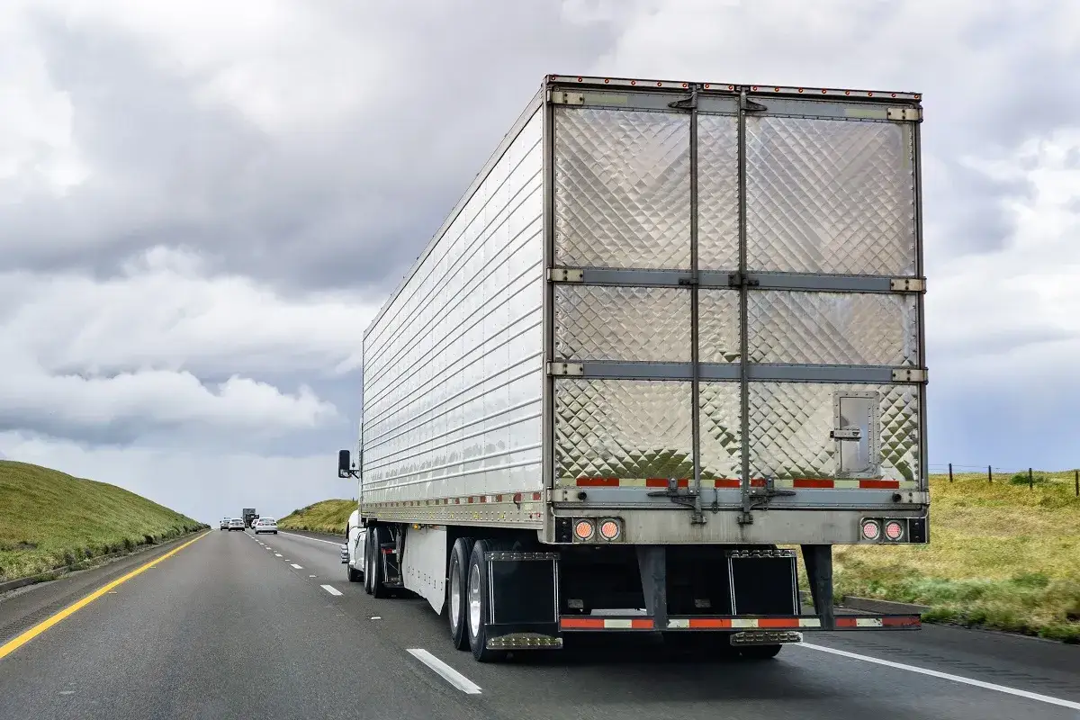 Ciężarówka na autostradzie, jej wysokość jest standardowa dla transportu.