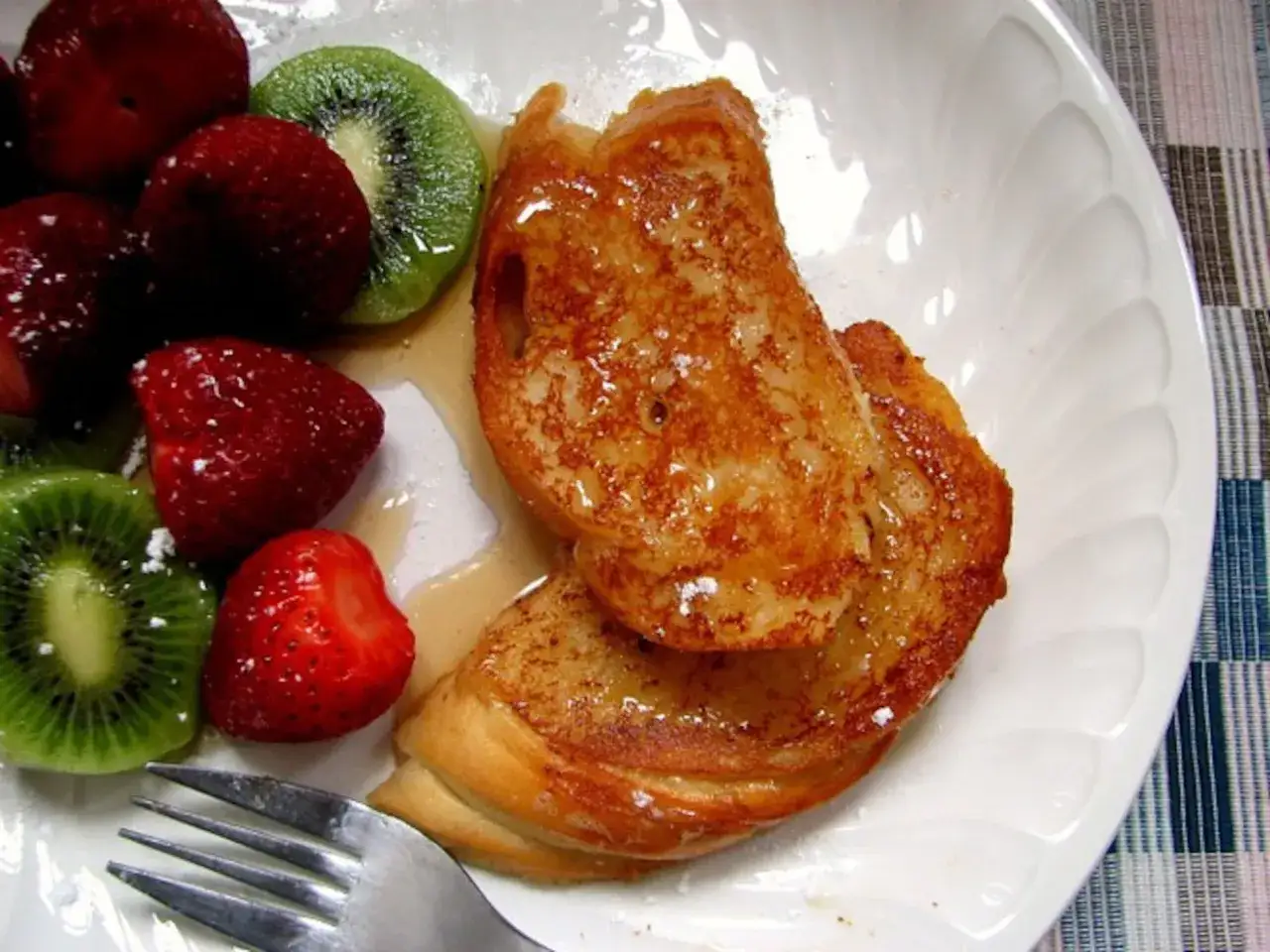 Tostadas francesas doradas con fresas y kiwi, un desayuno perfecto.