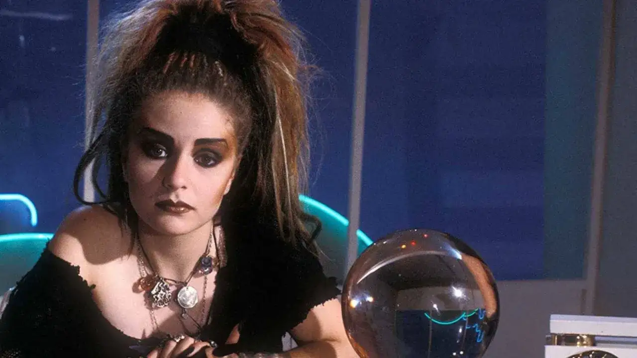 Chica con maquillaje dramático y peinado voluminoso, evocando la estética de la new wave music, junto a una esfera de cristal.