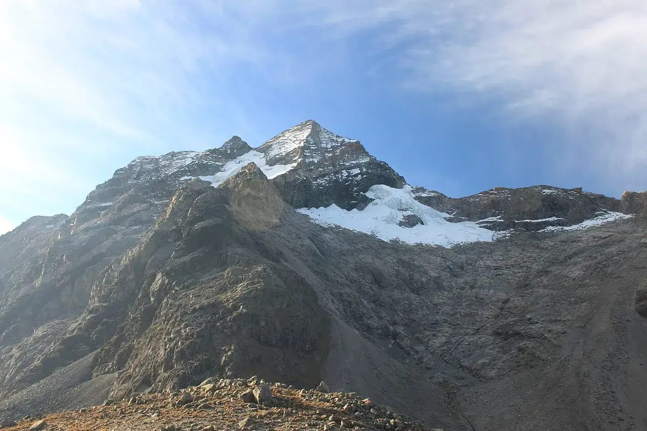 Majestätischer Pico Cristóbal Colón, ein schneebedeckter Gipfel, ragt unter blauem Himmel auf.