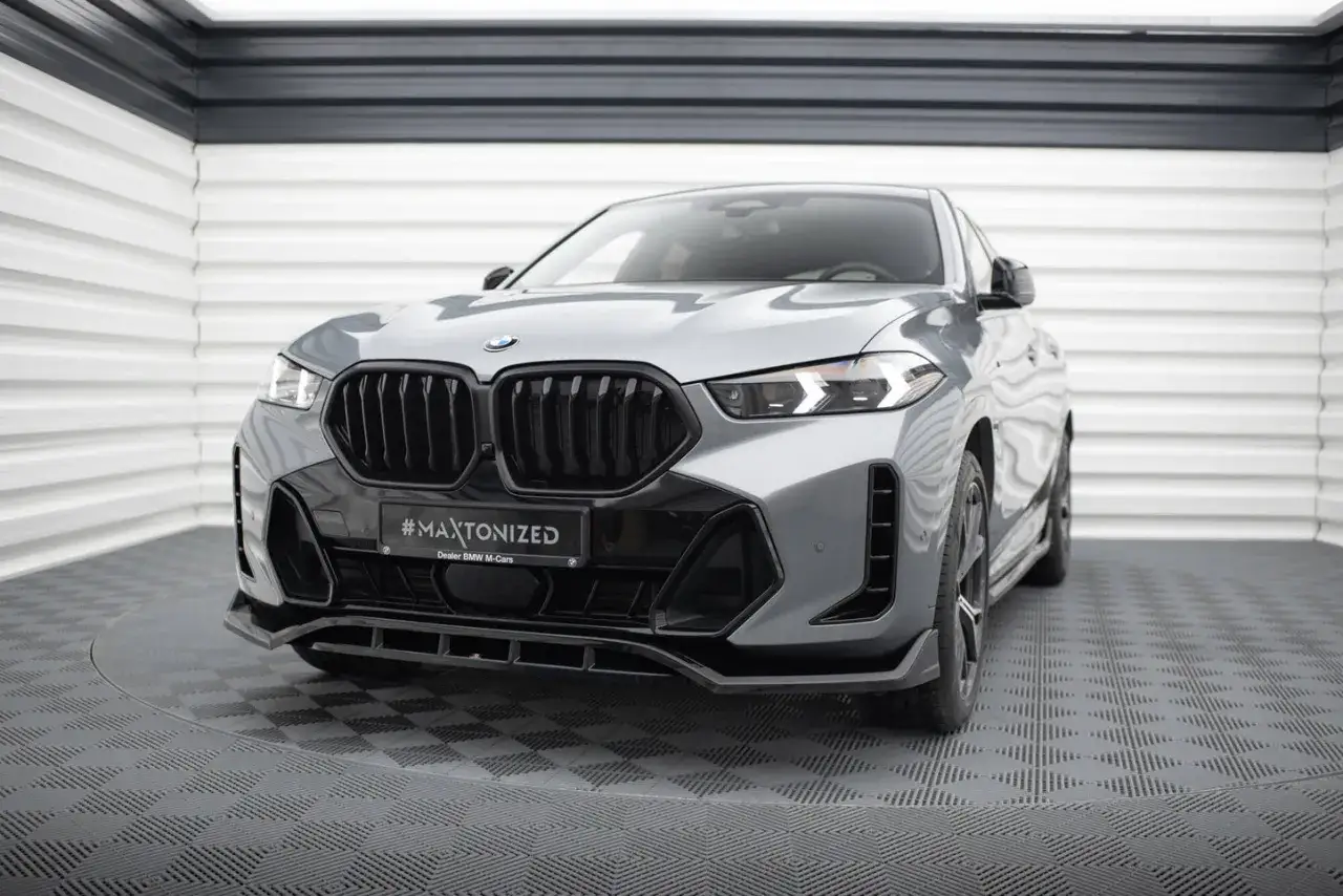Szary BMW X6M z czarnym grillem i agresywnym zderzakiem, gotowy do podboju dróg.