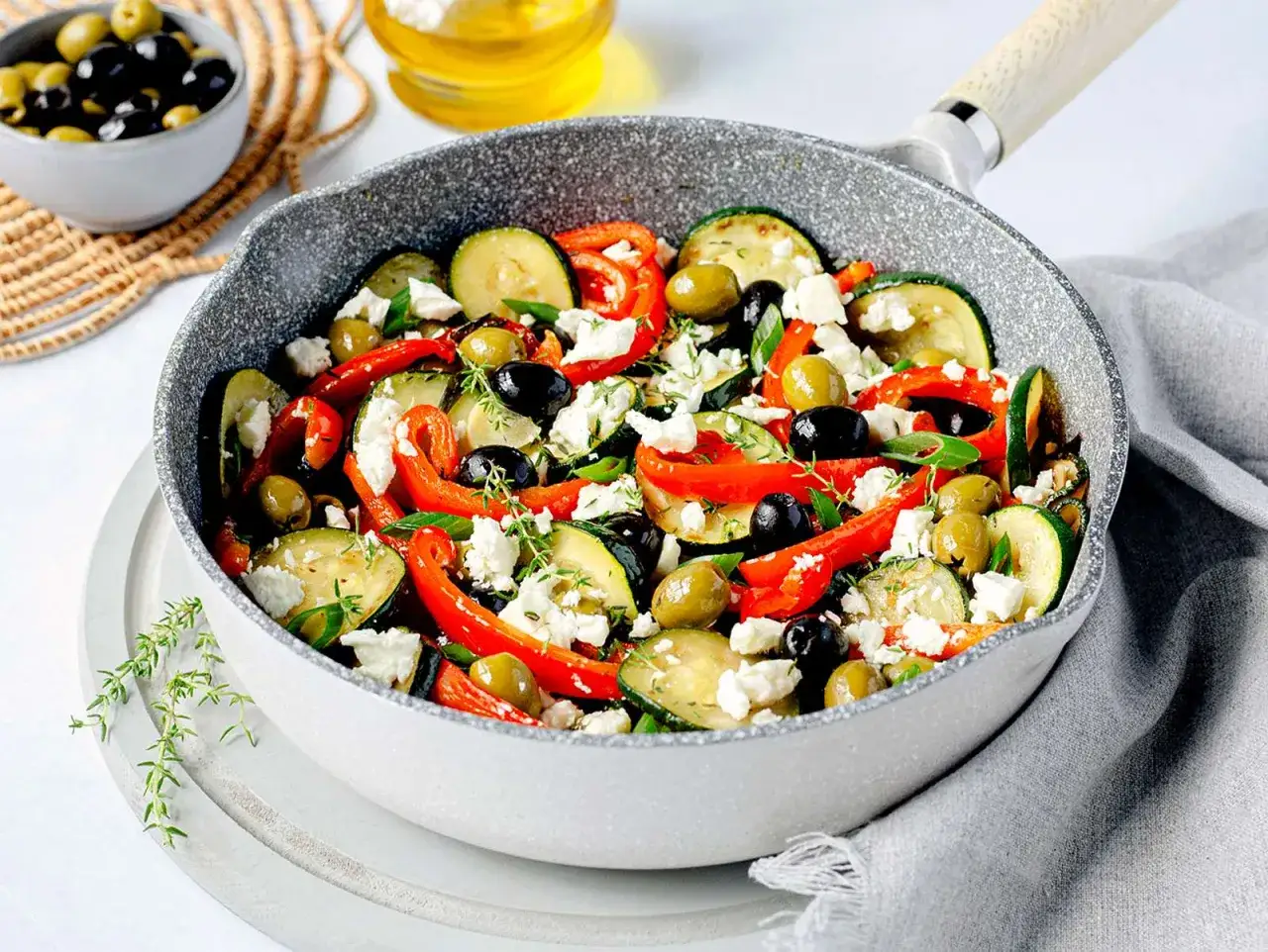 Bunte zucchini pfanne mit Paprika, Oliven und Feta. Ein mediterraner Genuss direkt aus der Pfanne.