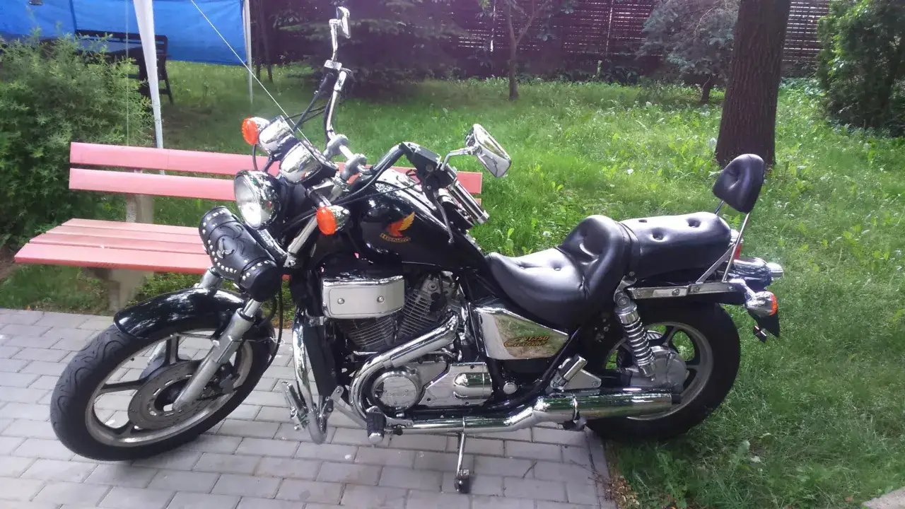 Czarny motocykl Honda Shadow 750 Custom, z chromowanymi elementami, gotowy do jazdy. Dane techniczne tego klasyka są imponujące.