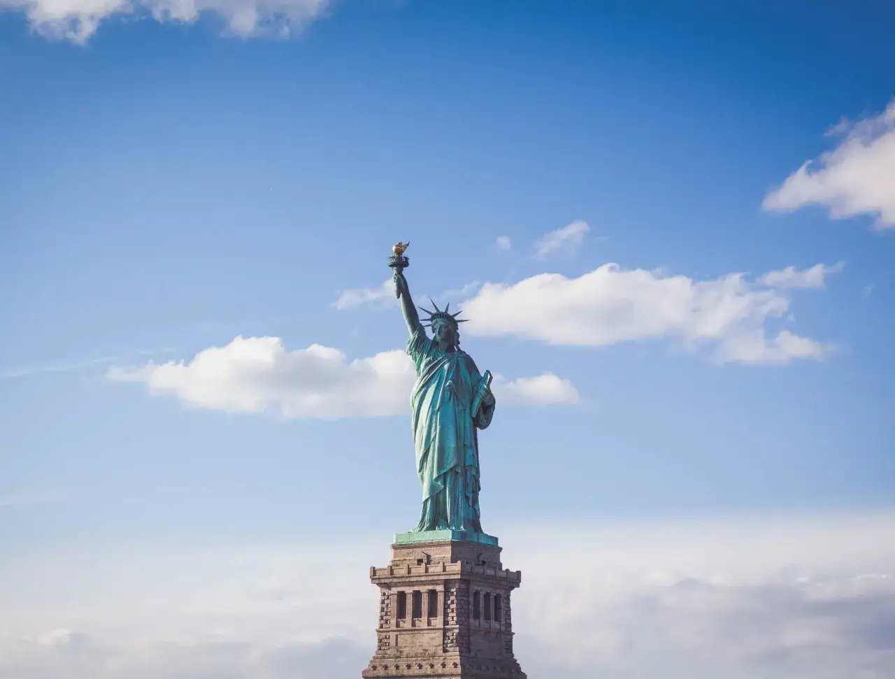 Statua Wolności na tle błękitnego nieba. Zastanawiasz się, ile kosztuje ubezpieczenie w USA?