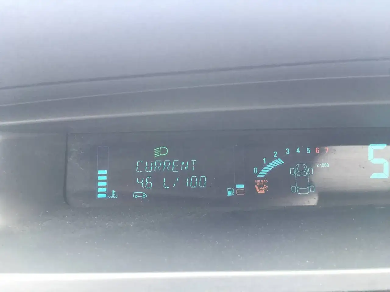 Instrumentpanel visar låg bränslemängd, aktuell förbrukning 4.6 L/100km och att airbag lampa lyser.