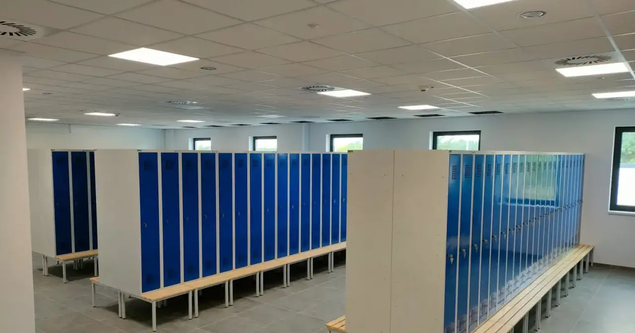 Szkoła gotowa na nowy rok. Woźny właśnie skończył porządkować szatnię z rzędami niebieskich szafek i drewnianymi ławkami.