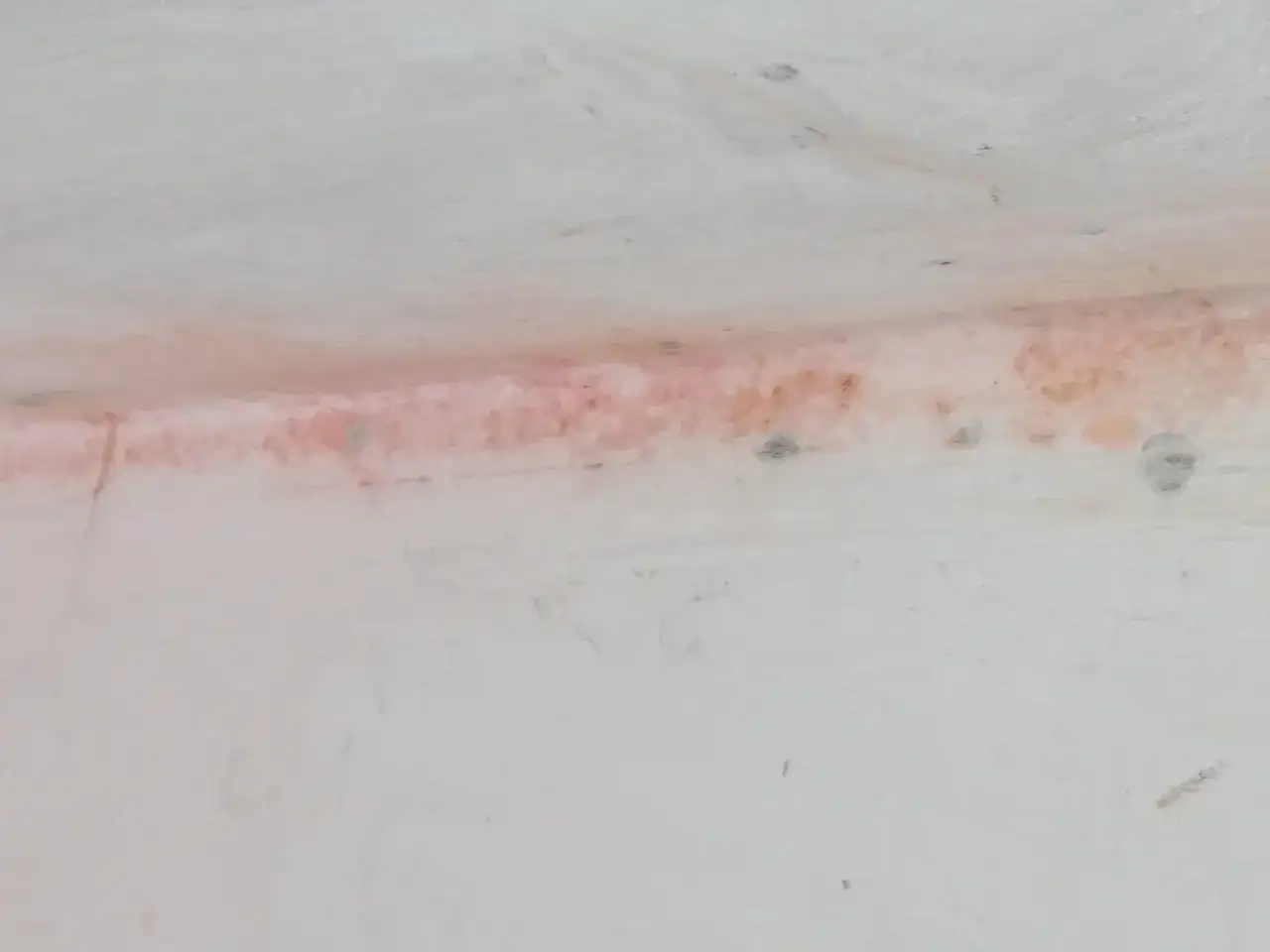 Macchie di muffa rossa sul muro, segno di umidit&agrave; e potenziale problema da affrontare.