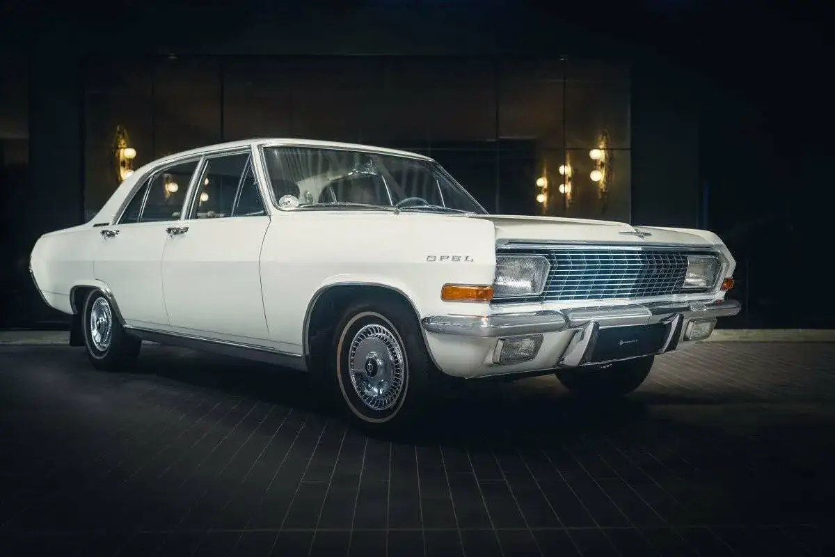 Weißer Opel Admiral, ein Klassiker mit Chromdetails und elegantem Design, steht im Scheinwerferlicht.