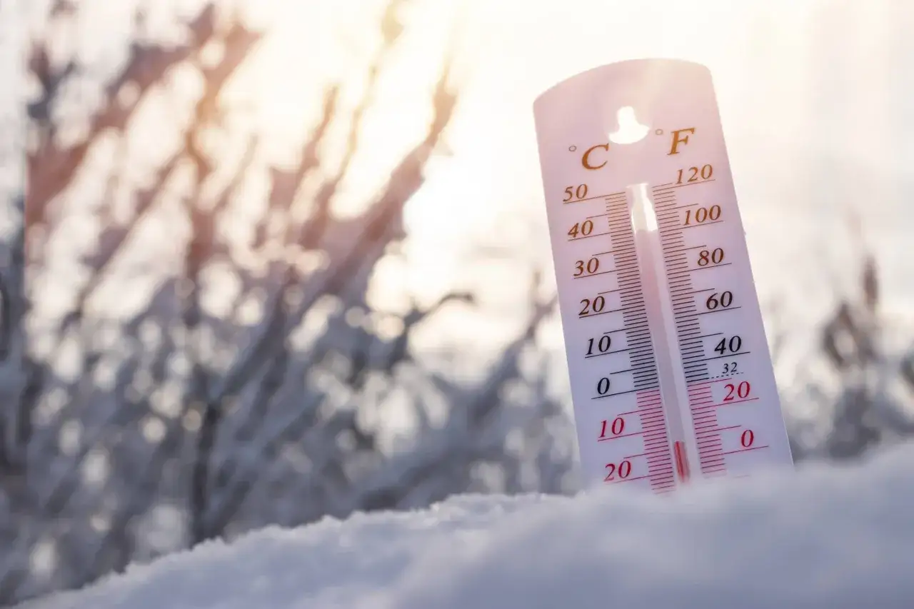 Termometr w śniegu pokazuje niską temperaturę, ostrzegając przed hipotermią.