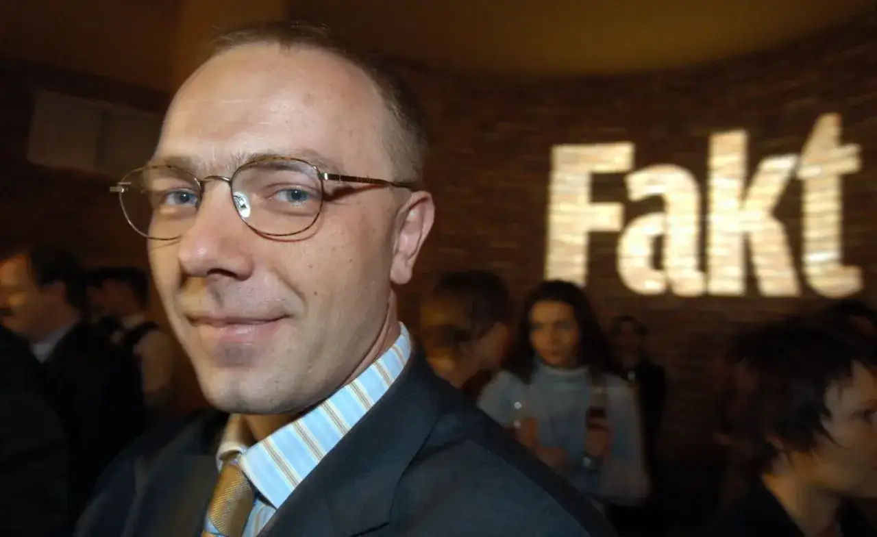 Grzegorz Jankowski w okularach, w tle logo 