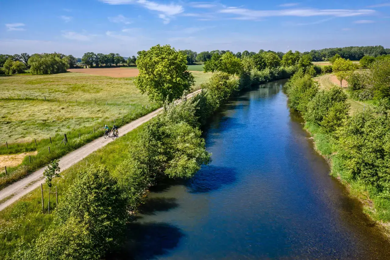 Zwei Radfahrer genie&szlig;en eine Deutschland Fahrradtour entlang eines Flusses.