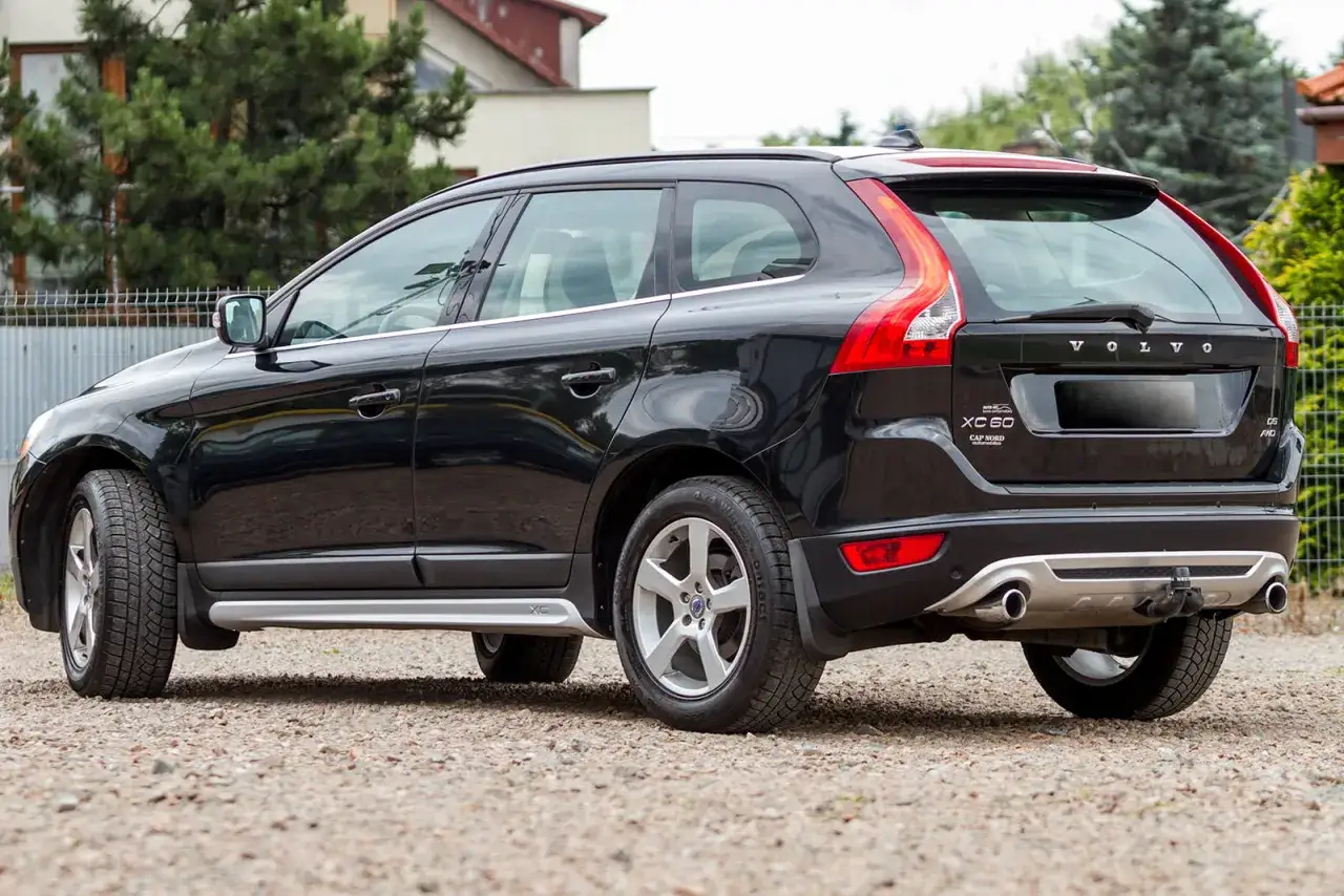 Czarne Volvo XC60 z zamontowanymi chlapaczami, gotowe na każdą drogę.