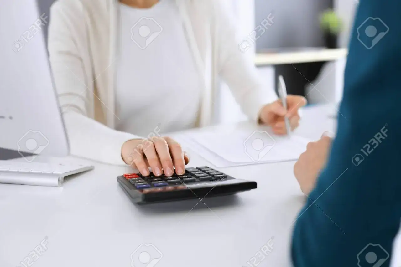 Osoba analizująca dokumenty finansowe przy biurku