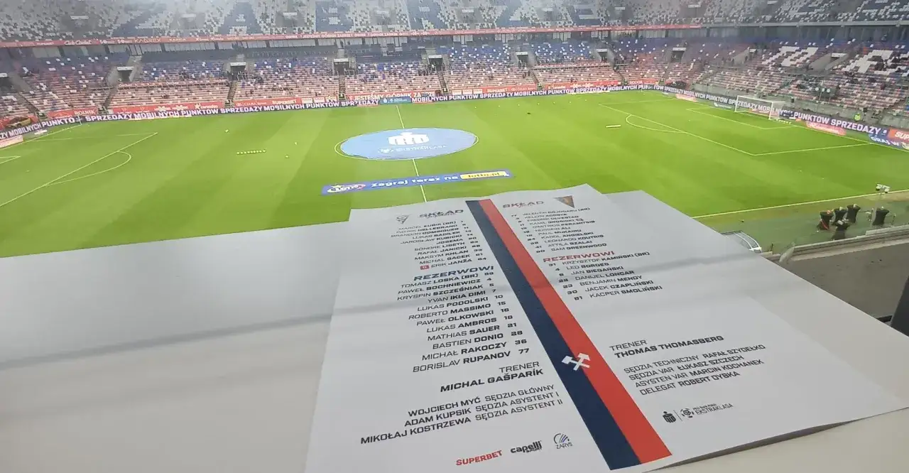 Składy: Pogoń Szczecin – Górnik Zabrze. Na pierwszym planie lista zawodników i sztabu obu drużyn, w tle piłkarskie boisko i trybuny.
