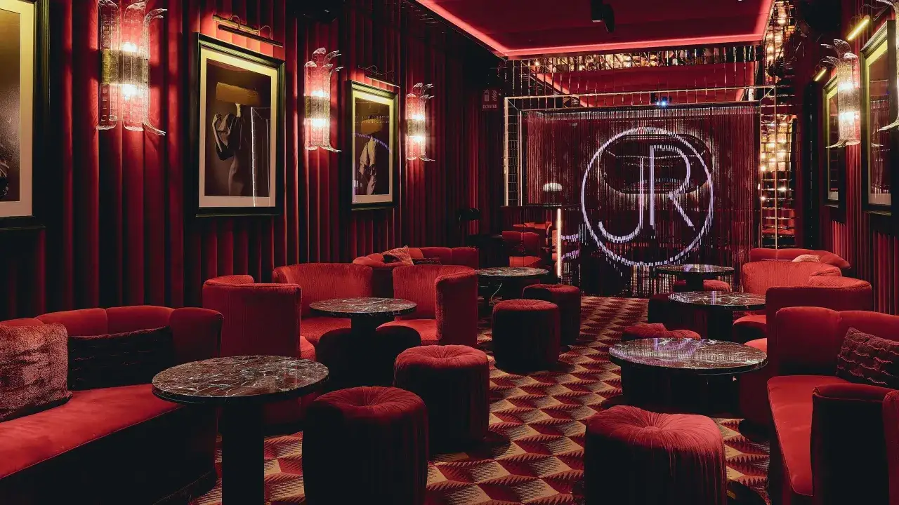 Un lujoso salón rojo con sofás de terciopelo, mesas de mármol y un letrero de neón con las iniciales JR. Así es Robuchon, un lugar para disfrutar.