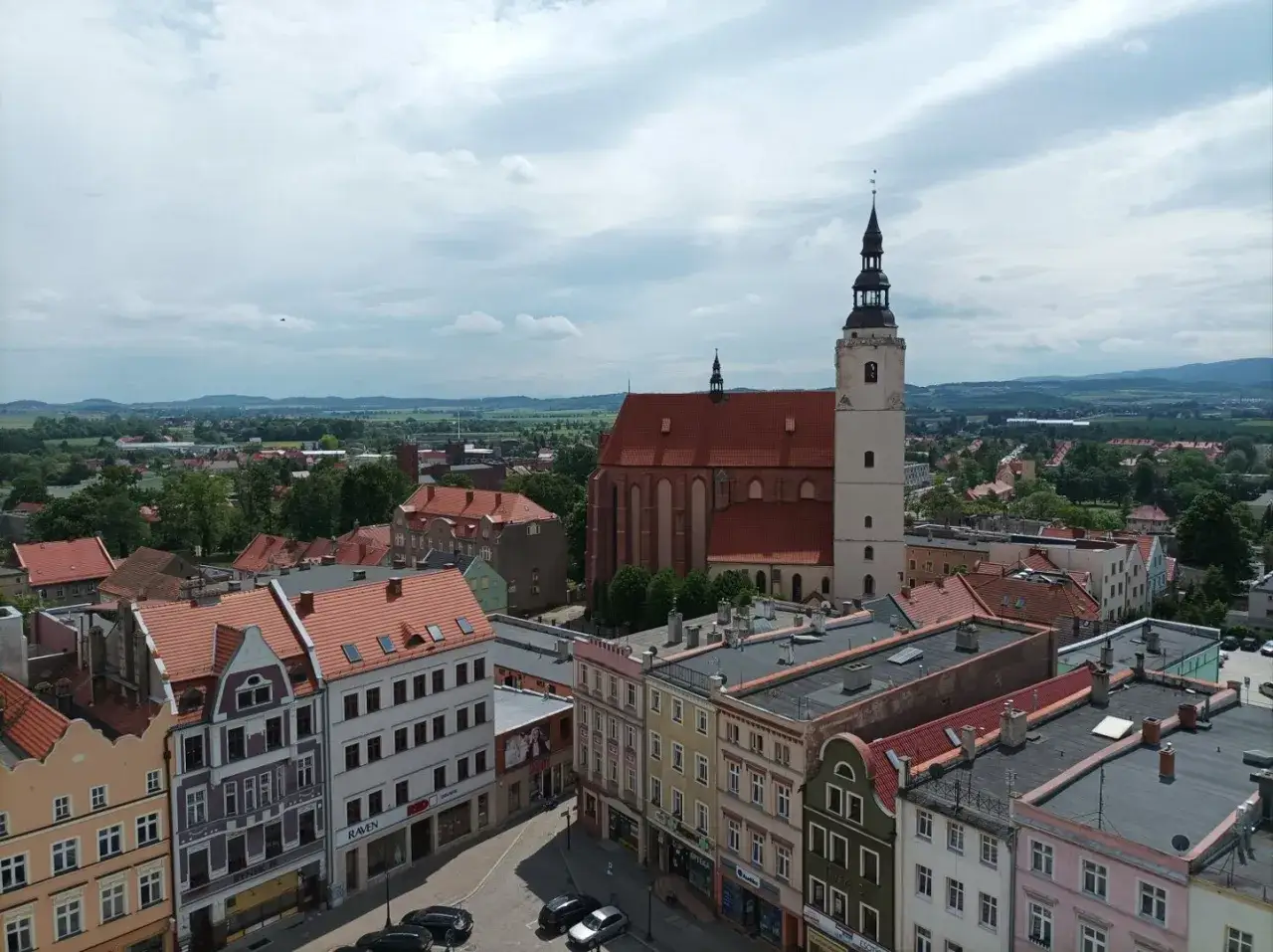 Widok na Dzierżoniów z lotu ptaka. Widać zabytkowy kościół, kolorowe kamienice i zielone krajobrazy. To świetne dzierżoniów atrakcje!