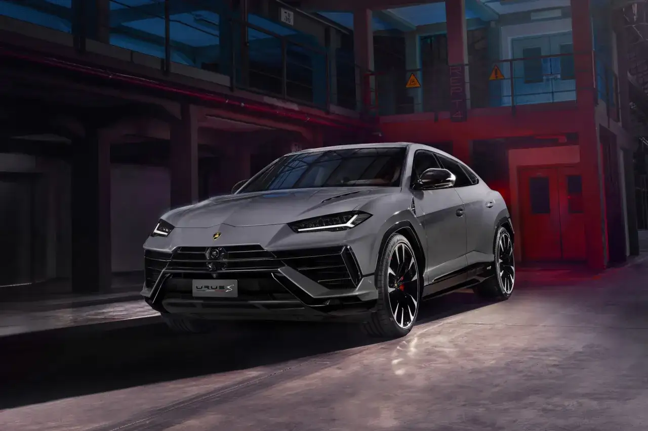 Szary Lamborghini Urus S, lśniący w industrialnym otoczeniu, gotowy na nocną przejażdżkę.