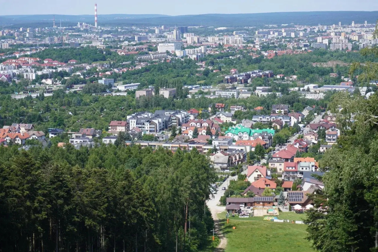 Widok na Kielce z góry, pokazujący zabudowania i zieleń. Wysokość nad poziomem morza jest tu wyraźnie odczuwalna.