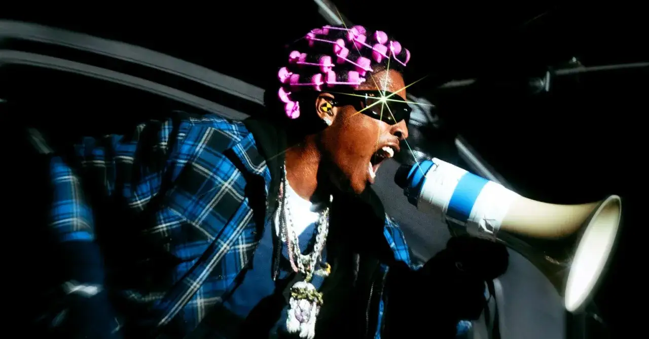 ASAP Rocky z różowymi wałkami na głowie i okularach przeciwsłonecznych krzyczy do megafonu. Zapowiedź ASAP Rocky new album.