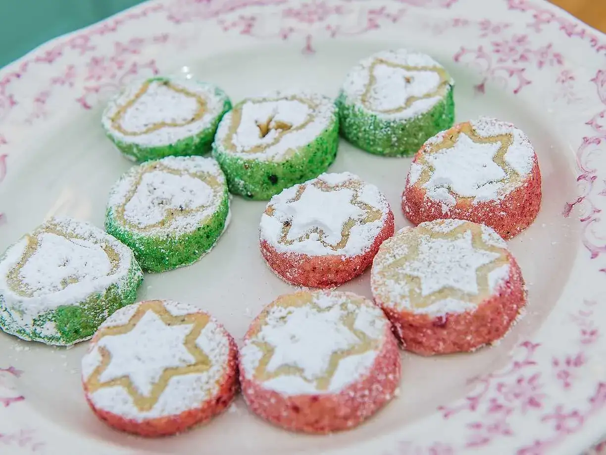 Sm&aring;, f&auml;rgglada kex med stj&auml;rnm&ouml;nster och hj&auml;rtan, pudrade med florsocker. Perfekta till fikat, som en del av ett brysselkex recept.
