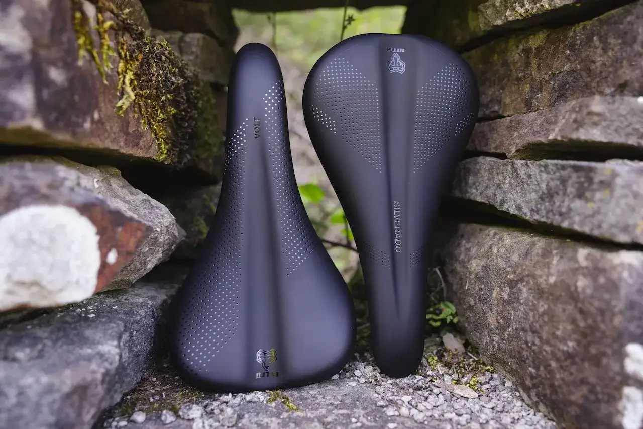 WTB Volt vs Silverado bike saddles, nestled between weathered stones. Which will conquer the trail?