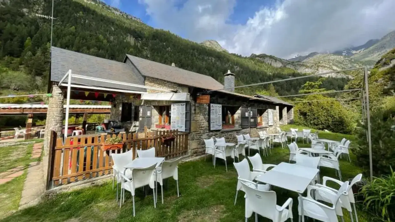Refugio de montaña con terraza y mesas listas para recibirte. Un lugar con encanto en Huesca, ¡quizás con una estrella Michelin!