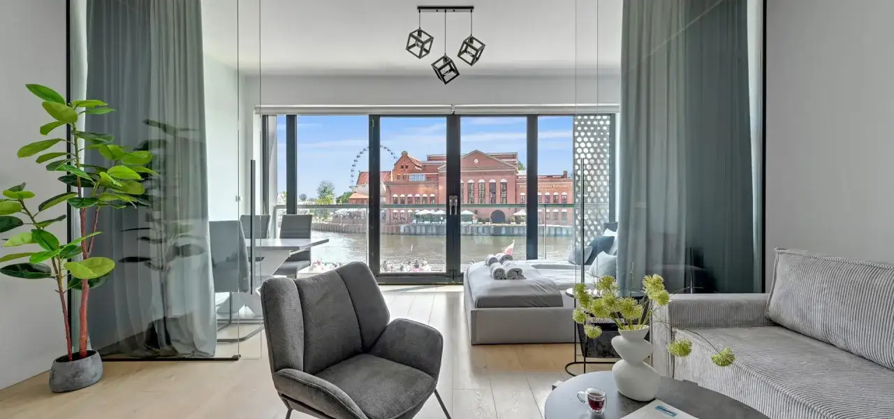 Nowoczesny apartament z widokiem na Motławę i budynki w okolicy Gdańska Targ Rybny. Wygodny wypoczynek z widokiem na panoramę miasta.