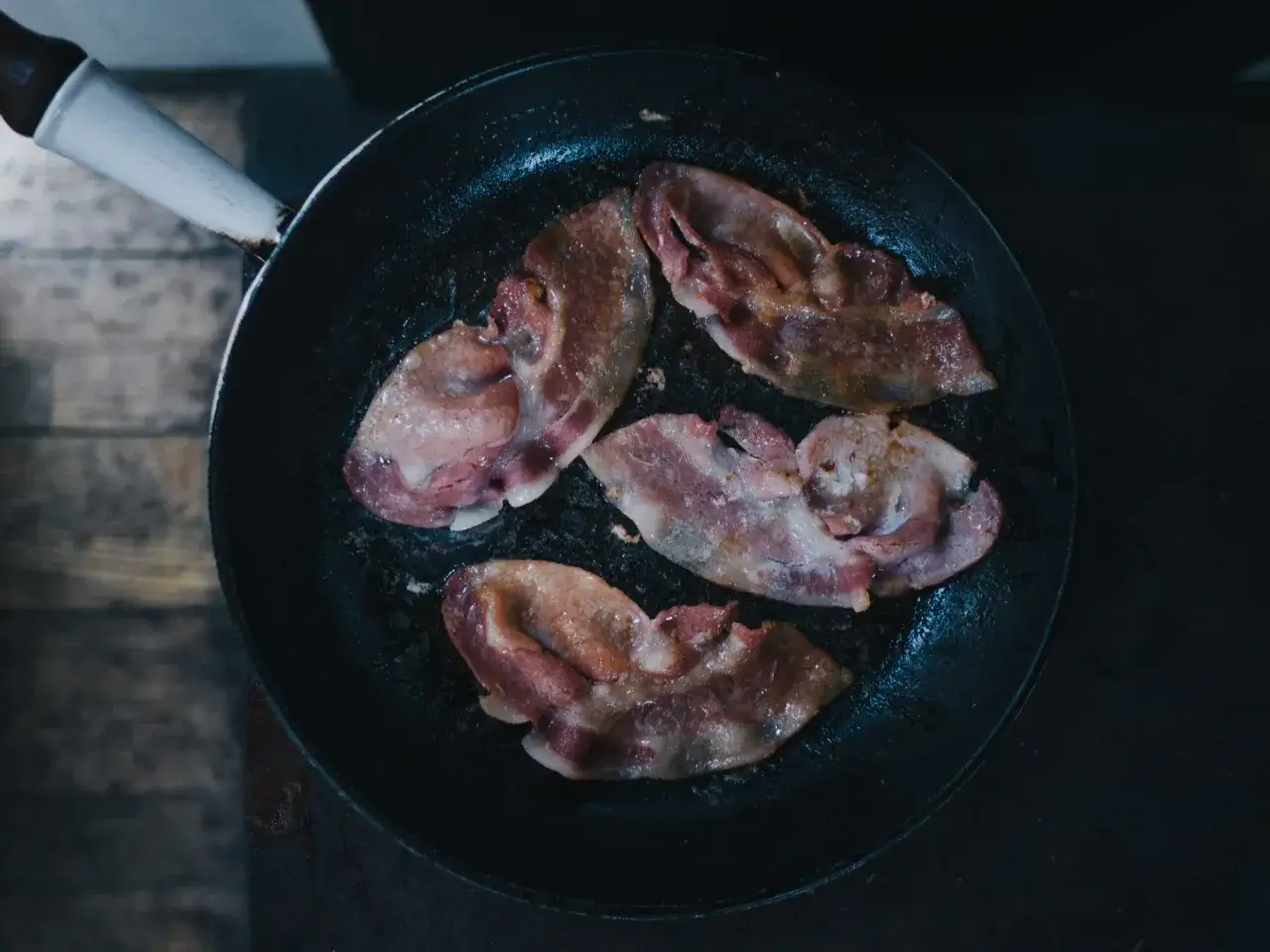 Boczek smaży się na patelni. Idealny składnik na śniadanie zgodne z dieta keto zasady.