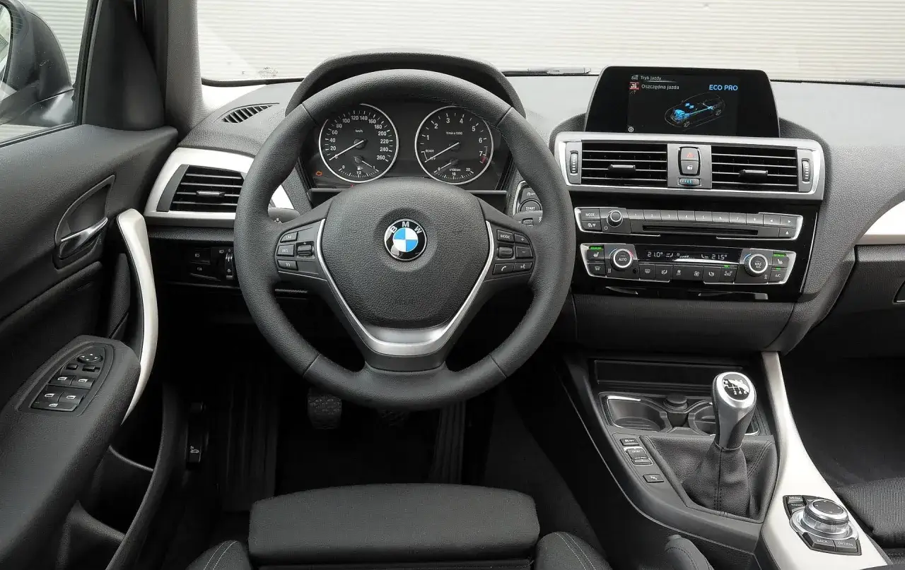 Wnętrze BMW f21 z kierownicą, deską rozdzielczą i ekranem multimedialnym. Widoczny tryb jazdy ECO PRO.