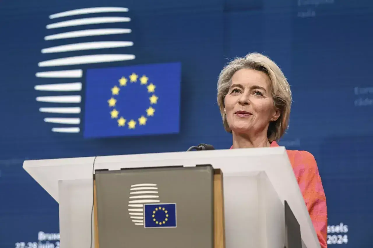 Ursula von der Leyen, kt&oacute;ra wprowadziła zielony ład, przemawia na tle flagi UE.
