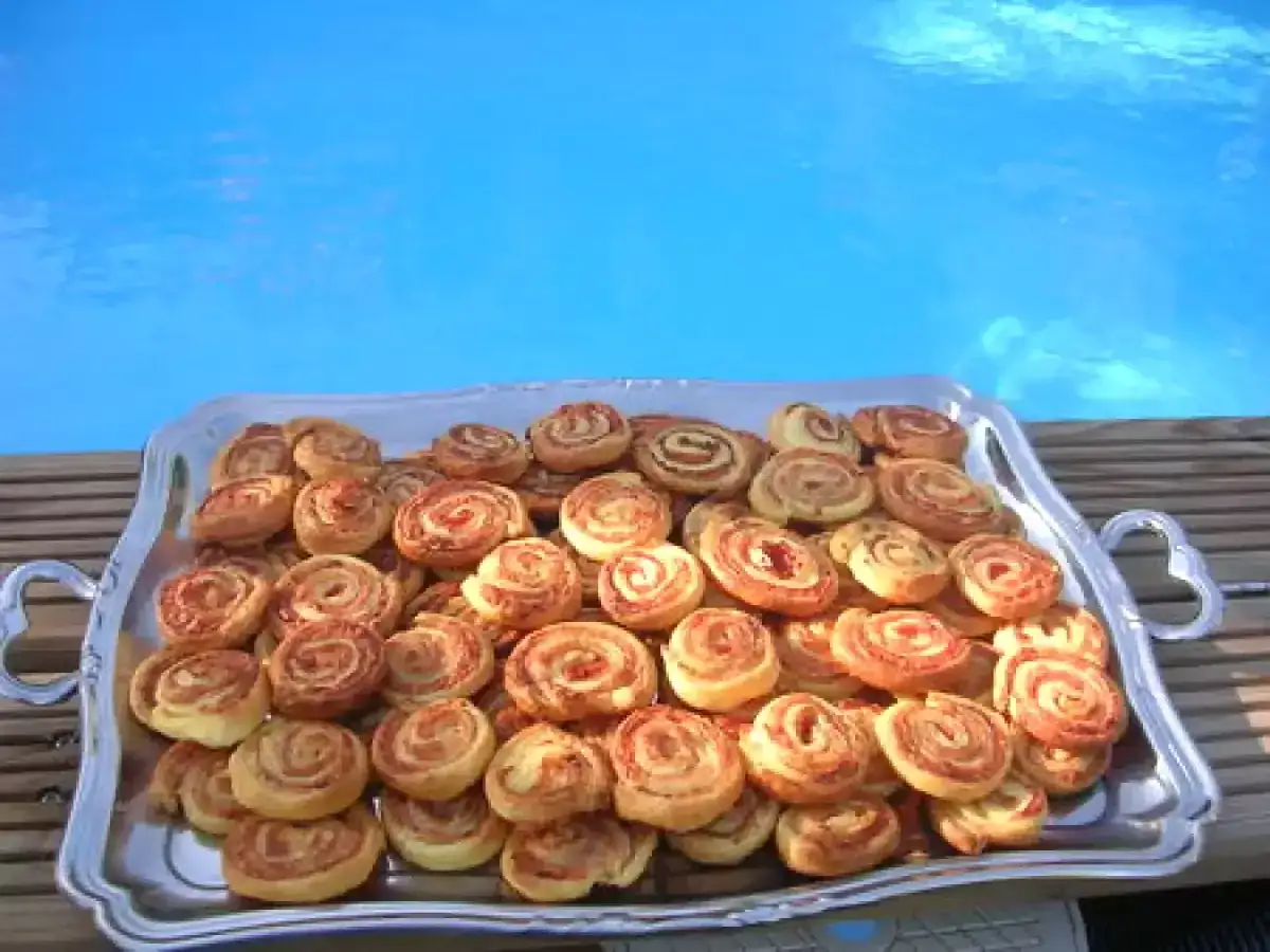 Plateau de petits fours salés en pâte feuilletée, prêts à être dégustés au bord de la piscine.