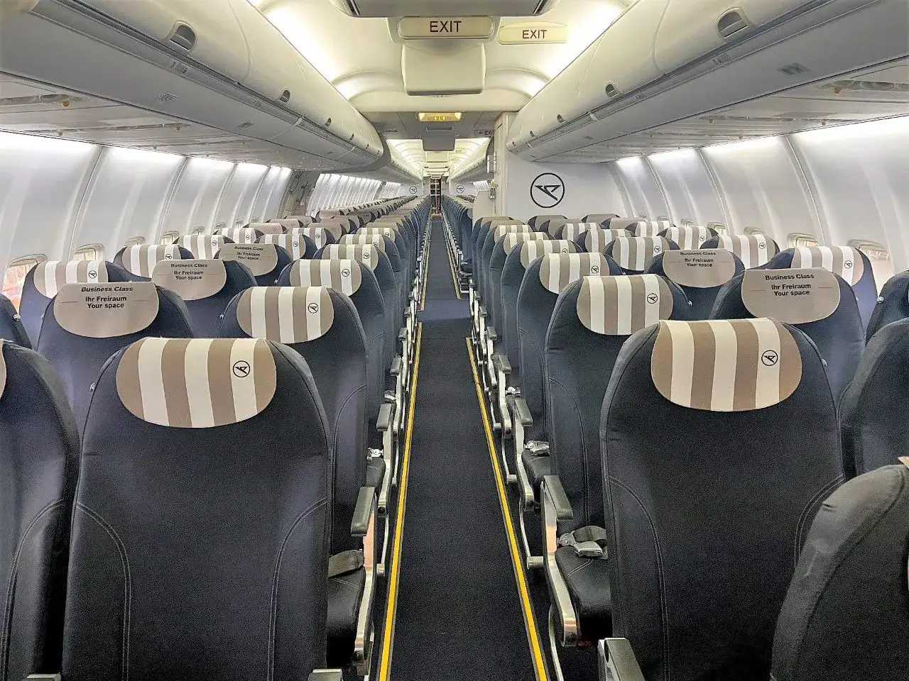 Wnętrze samolotu Boeing 757-300 z rzędami pustych foteli klasy biznes.