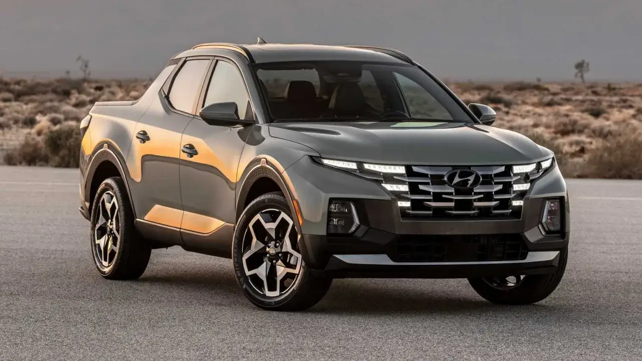 Szary Hyundai Santa Cruz z nowoczesnym grillem i światłami LED stoi na pustynnej drodze.
