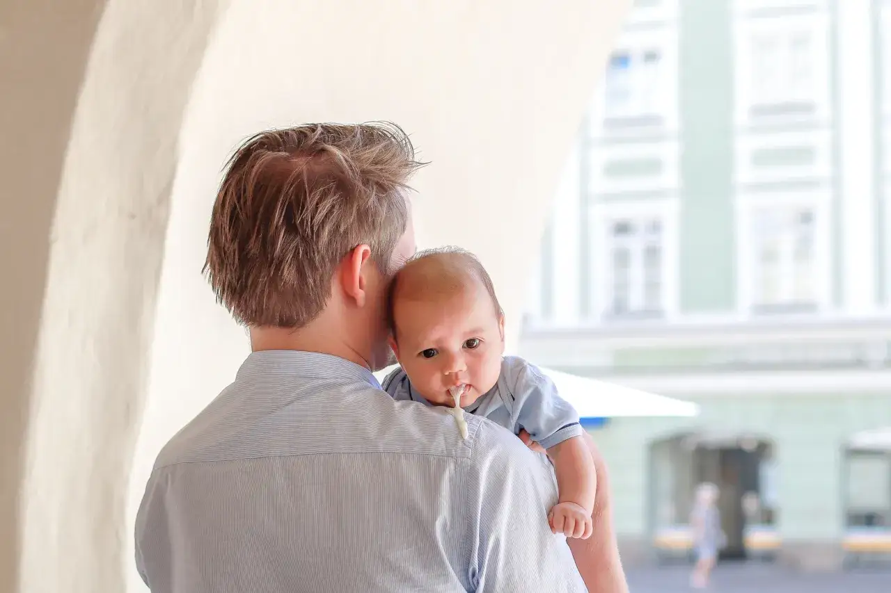 En pappa b&auml;r sin bebis som har lite rap p&aring; tr&ouml;jan.