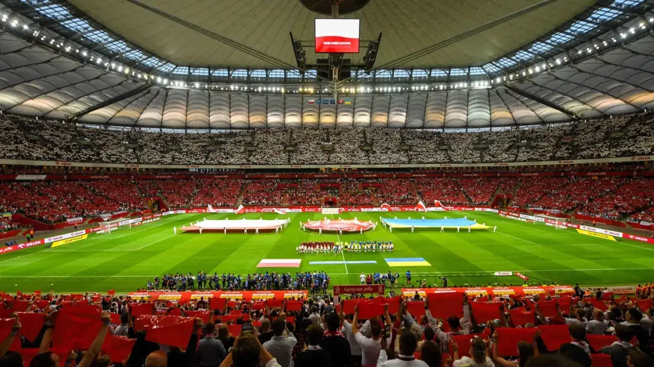 Stadion wypełniony kibicami w biało-czerwonych barwach, tworzącymi mozaikę. Na murawie flagi Polski i Ukrainy, symbol solidarności. To obraz przed meczem, który może być początkiem wielkiej remontady.
