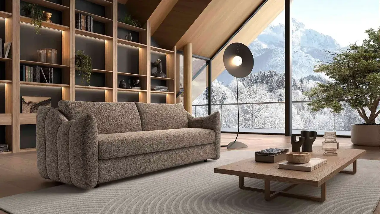 Canapé confortable dans un salon moderne avec vue sur la montagne enneigée. Avis sur la maison convertible.