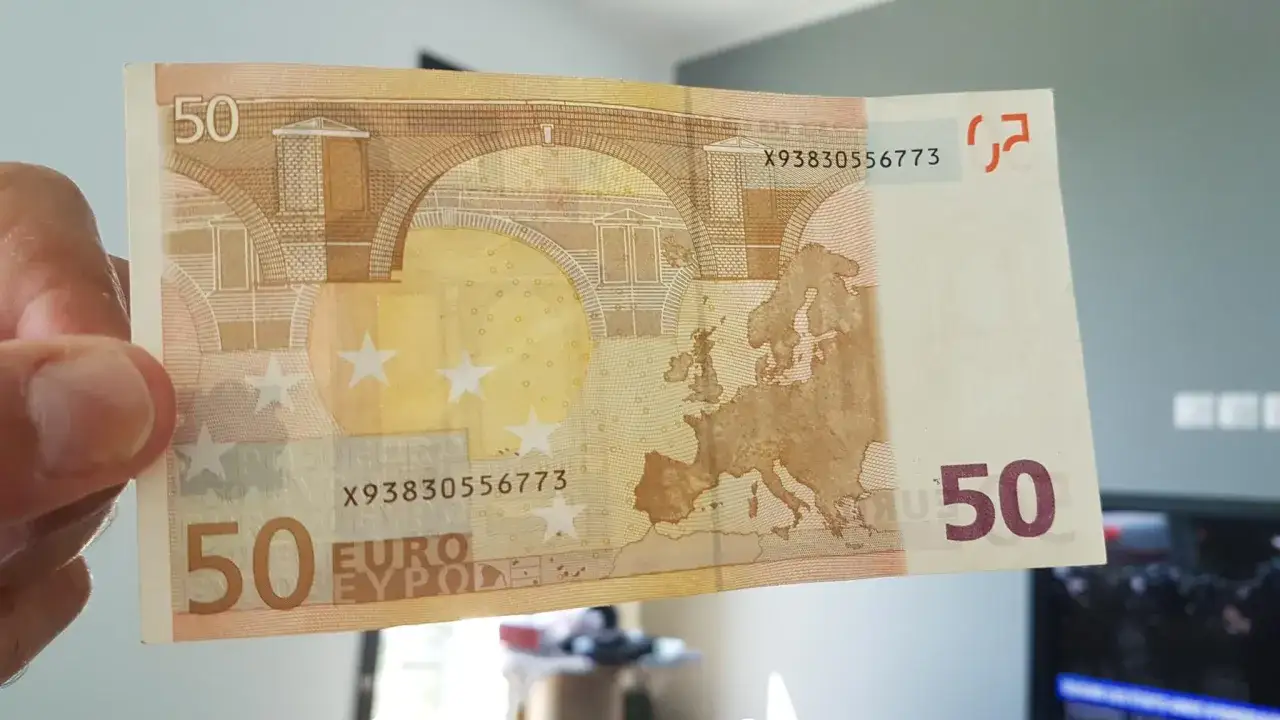 Un billet de 50 euros 2002, avec sa carte de l'Europe et ses &eacute;toiles, est tenu dans une main. Sa validit&eacute; est assur&eacute;e.